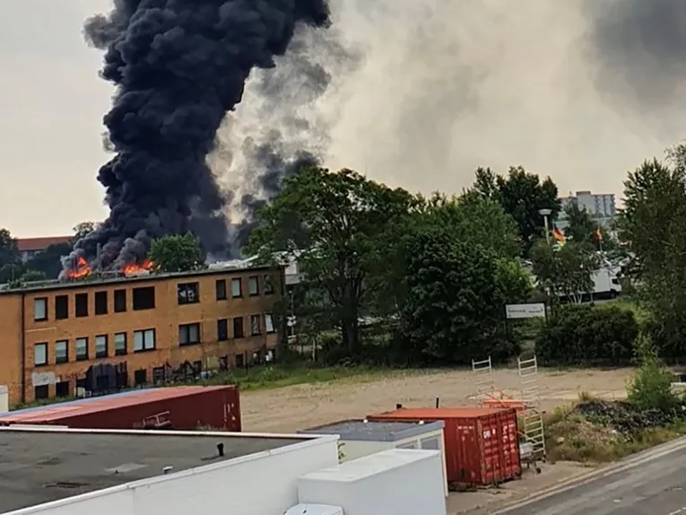 Dichter Brandrauch und Flammen schlagen aus einem Haus.